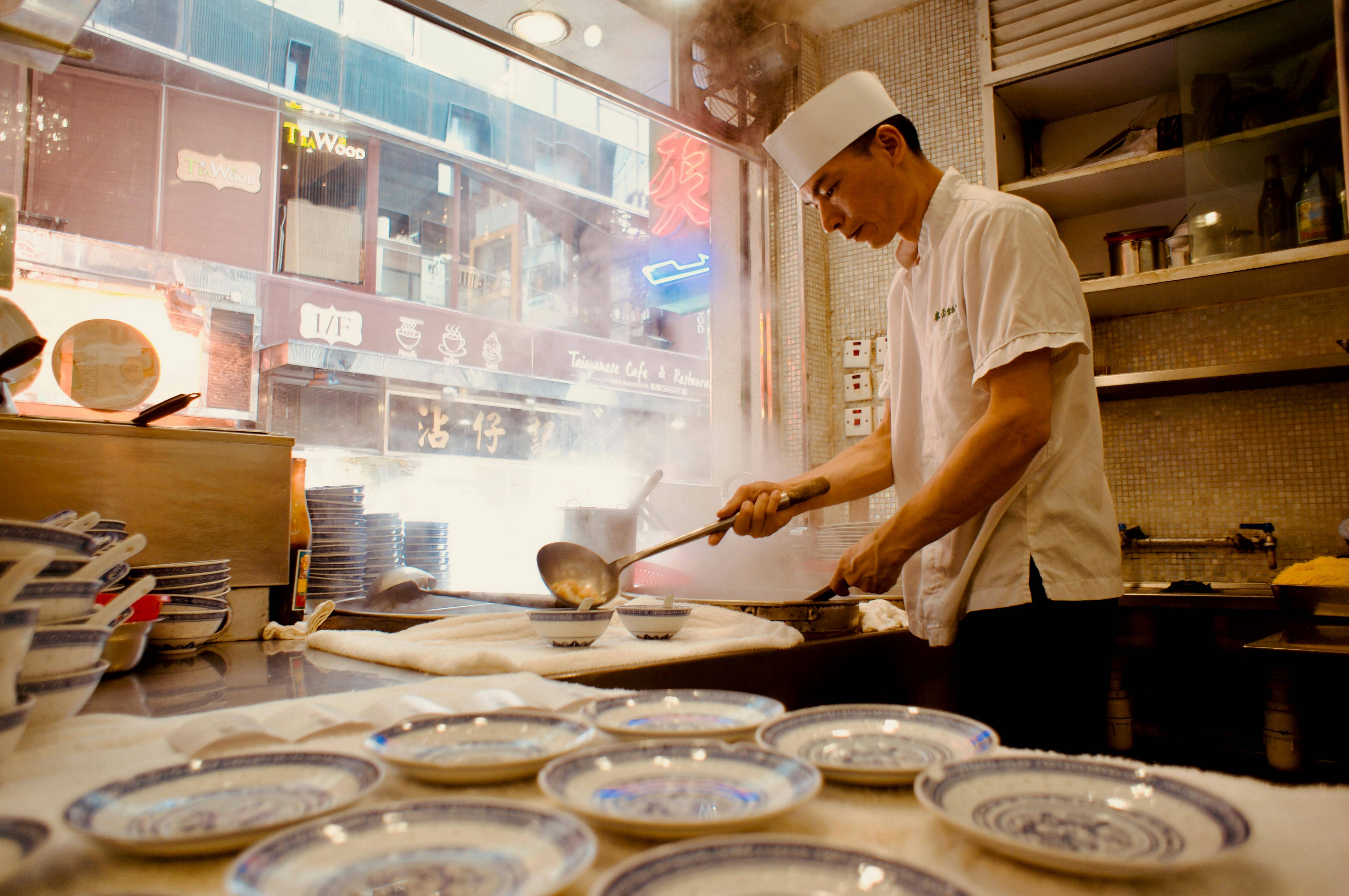 Man preparing traditional dishes in a Hong Kong restaurant